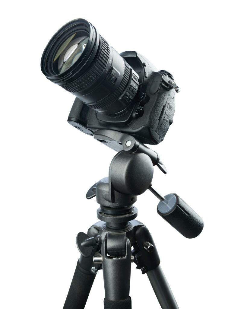 DSLR camera on tripod, isolated on white background